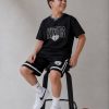 Σετ αγοριού με μαύρη κοντομάνικη μπλούζα KINGS League 32 και μαύρη αθλητική βερμούδα με λευκές ρίγες.
