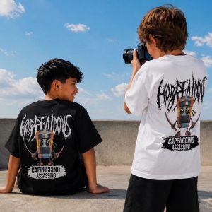Σετ αγοριού Cappuccino Assassino με κοντομάνικο T-shirt και μεγάλο τύπωμα στην πλάτη, συνδυασμένο με μαύρη βερμούδα
